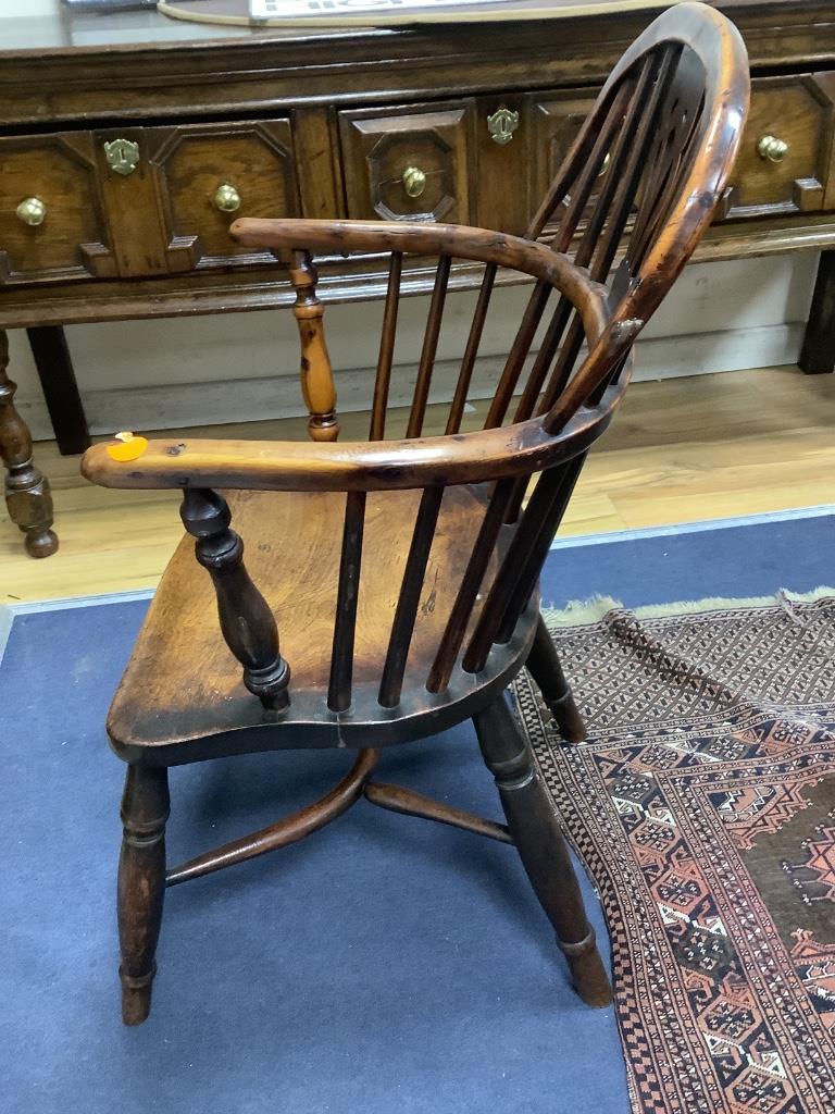 A harlequin set of seven early 19th century yew and elm splat back elbow chairs